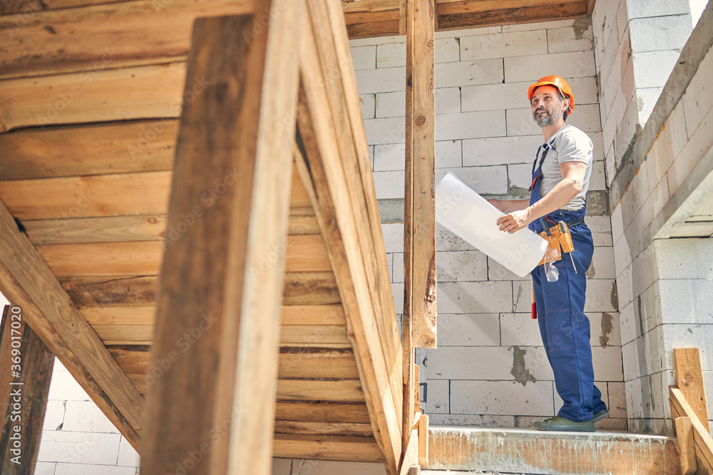 Contented builder in a helmet looking up Contented builder in a helmet looking up