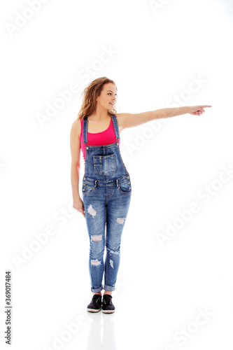 Young woman pointing to somewhere, isolated over a white background