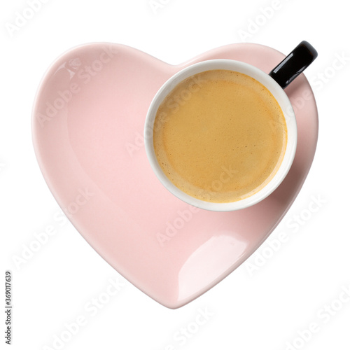 Cup of coffee on pink heart shaped plate isolated on white. Top view.