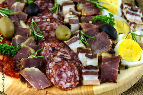 Sliced meat and sausage on a wooden board