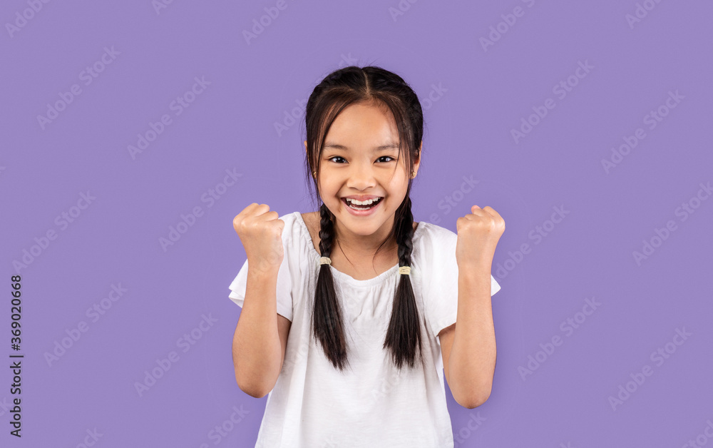 Little Chinese Girl Gesturing Yes Celebrating Victory On Purple Background