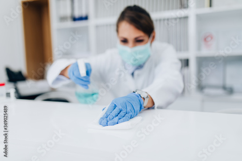 Φωτογραφία Young female practitioner or nurse with face protective mask working at clinic reception desk