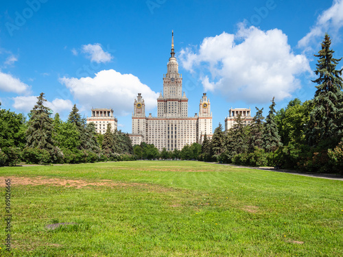 view of The Main Building of Moscow State University (Lomonosov State University of Moscow) and green lawn in courtyard in sunny summer day