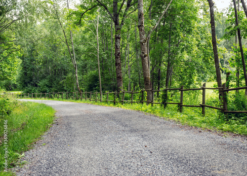 landscape with a simple country road and a wooden fence along the edge, summer