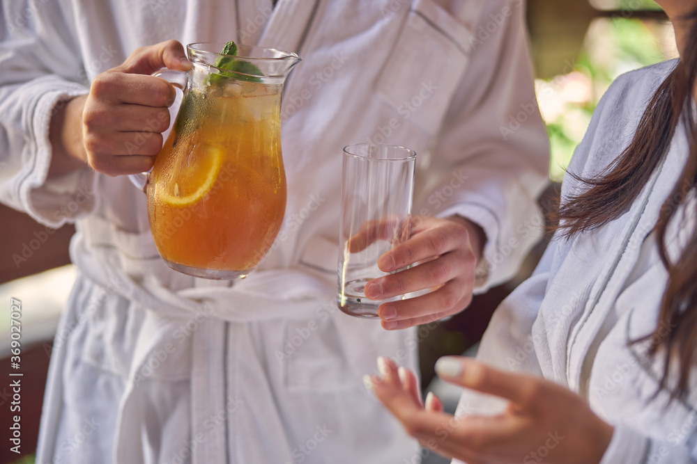 Man hand pouring orange lemonade in glass Man hand pouring orange lemonade in glass