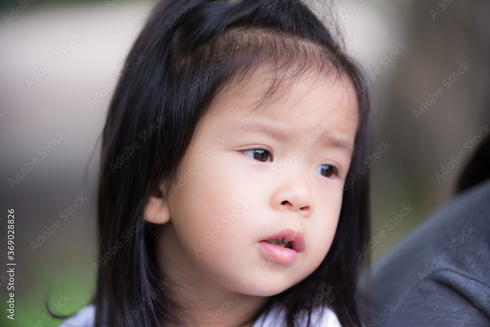 Preschool child girl keeps food on her cheeks. The little Asian daughter looked at the camera and smiles a little. Kid 3 years old. Close up shot. Preschool child girl keeps food on her cheeks. The little Asian daughter looked at the camera and smiles a little. Kid 3 years old. Close up shot.