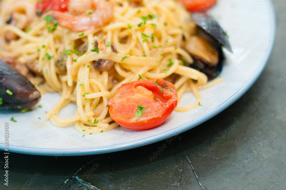 Spaghetti pasta with shrimp, mussels, tomatoes and cheese, close-up, copy space. Tasty, traditional food from Italy Spaghetti pasta with shrimp, mussels, tomatoes and cheese, close-up, copy space. Tasty, traditional food from Italy