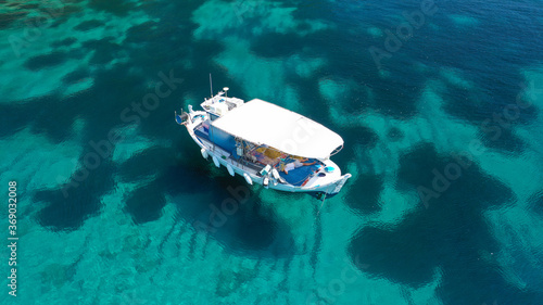 Fototapeta Naklejka Na Ścianę i Meble -  Aerial drone photo of beautiful fishing boat anchored in turquoise sea of Stafilos bay, Skopelos island, Sporades, Greece