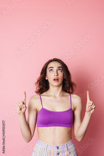 Image of redhead shocked woman in bra pointing fingers upward