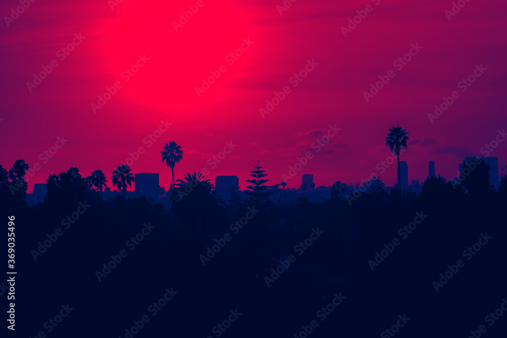 Sunset over Los Angeles skyline with buildings and palm trees in California - red and blue duotone colors