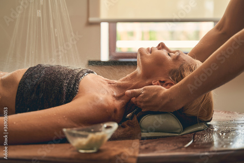 Young woman with spa essentials in wellness center