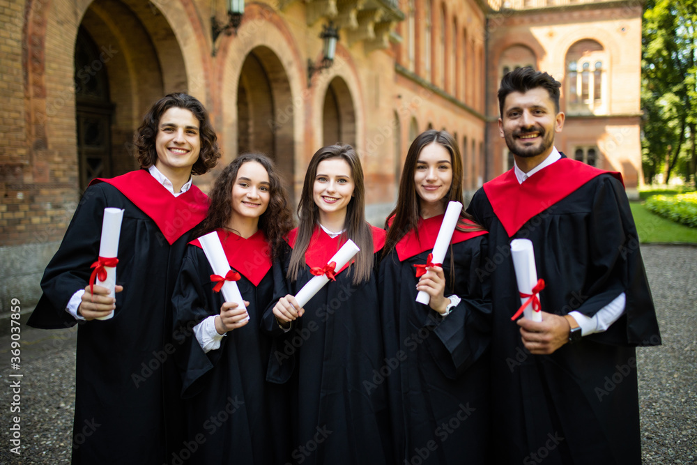 Young happy group of university graduates at graduation ceremony