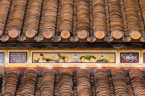 Hue, ancient capital of Vietnam. Yellow enamelled roof tiles architecture detail