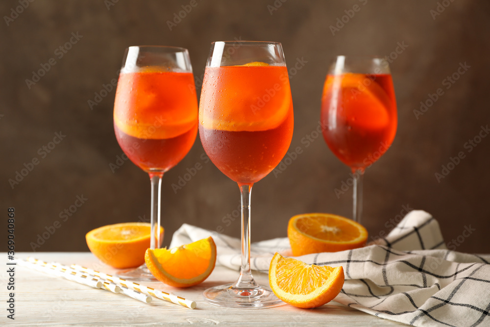 Composition with aperol spritz cocktail against brown background. Summer cocktail