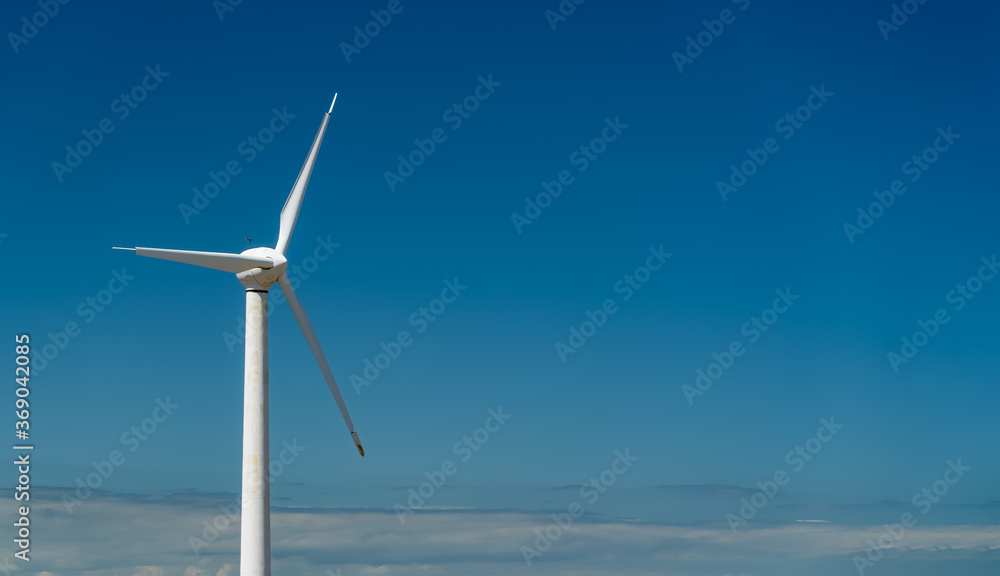 Wind turbine on blue sky with copy space