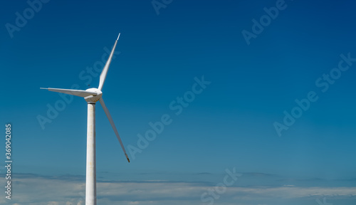 Wind turbine on blue sky with copy space