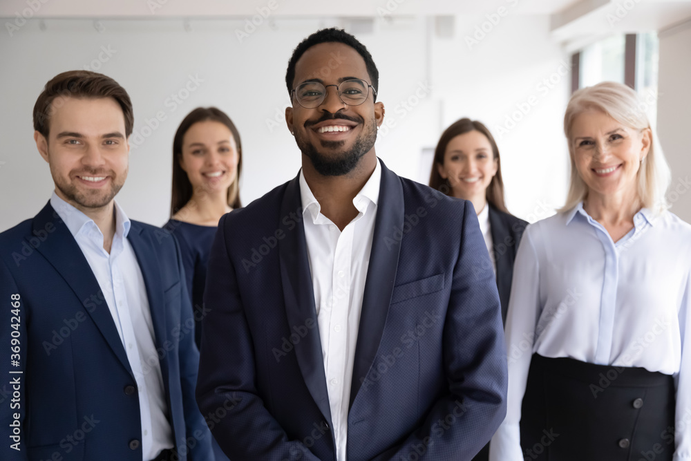 Diverse professionals bank employees company staff members in formal wear, 5 businesspeople lead by African ethnicity leader posing standing together in office. Young aged specialists portrait concept Diverse professionals bank employees company staff members in formal wear, 5 businesspeople lead by African ethnicity leader posing standing together in office. Young aged specialists portrait concept