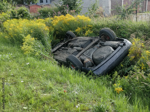 Car flipped over on the roof in the grass grave. Vehicle accident. Speed limitation abuse.