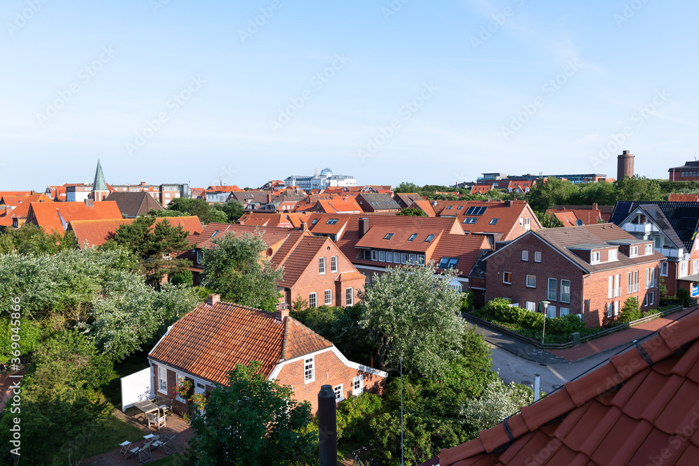 Overview of the holiday resort Juist with red stone houses in summer