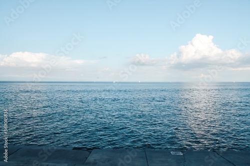 Beautiful and calm sea on a sunny clear day  and ships sail in the distance