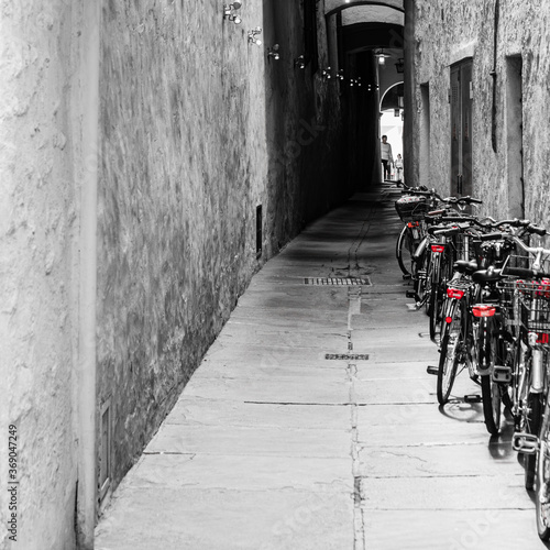 Fototapeta Naklejka Na Ścianę i Meble -  Bicycles in an alleyway in Bolzano, Italy.  Spot colour.
