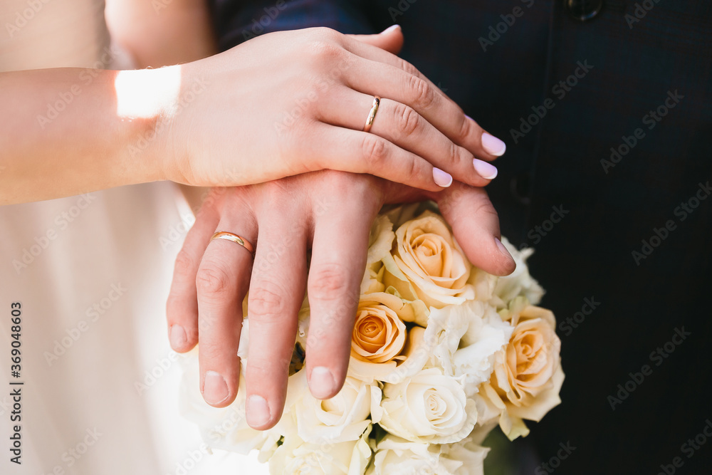Hands of the bride and groom with rings, folded on a bouquet Hands of the bride and groom with rings, folded on a bouquet
