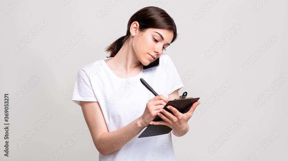 Business call. Reservation list. Confident woman with clipboard taking order on phone isolated on white copy space. Appointment arrangement. Client service. Business call. Reservation list. Confident woman with clipboard taking order on phone isolated on white copy space. Appointment arrangement. Client service.