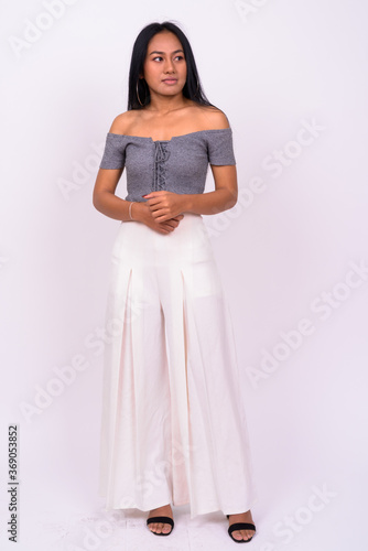 Young beautiful Asian woman against white background © Ranta Images