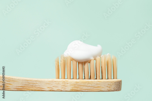 Photography Bamboo toothbrush with toothpaste on mint background with copy space