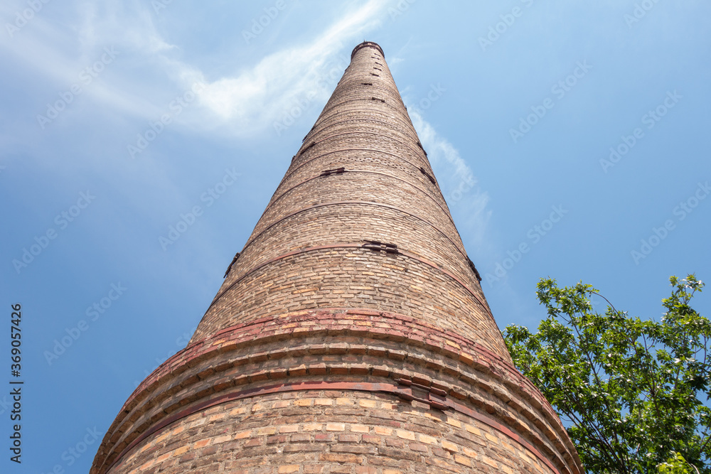 Old red brick wall against the blue sky. Bottom view.