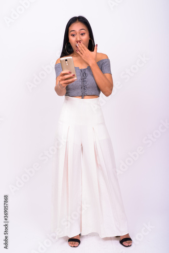 Portrait of young beautiful Asian woman using phone
