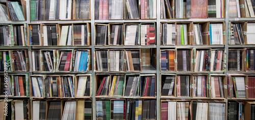 Neatly stacked records sit in rows on shelves at a warehouse ready for sale or distribution.