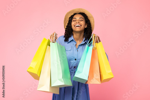 Black Girl Laughing Carrying Shopping Bags Standing On Pink Background