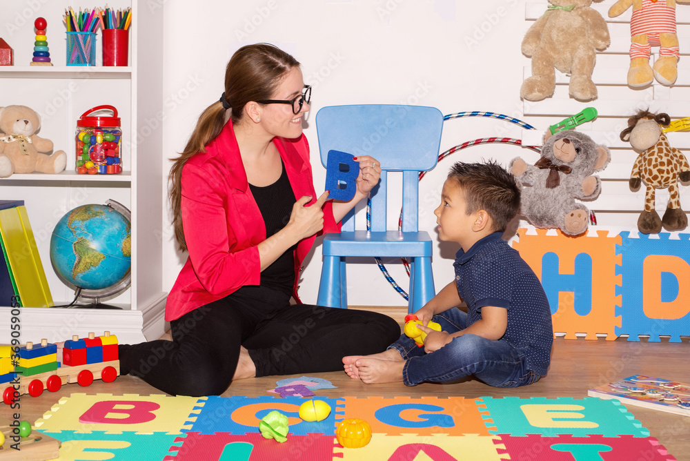 Little boy during lesson with his speech therapist. - obrazy, fototapety, plakaty 