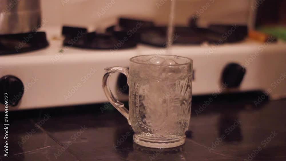 Close up Filling a transparent glass with cold water from a glass bottle Close up Filling a transparent glass with cold water from a glass bottle