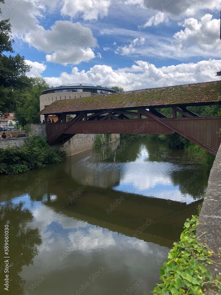 Schwäbisch Hall, Germany - July 11, 2020: Medieval wooden bridge over the river Kocher in Schwaebisch Hall, Baden-Wuerttemberg, Germany Schwäbisch Hall, Germany - July 11, 2020: Medieval wooden bridge over the river Kocher in Schwaebisch Hall, Baden-Wuerttemberg, Germany