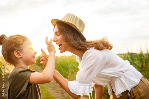 Canvas Print Happy mom and baby playing together in the field