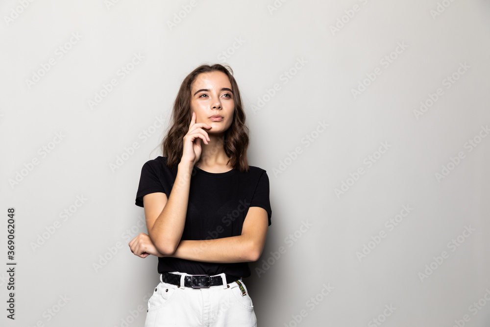Young thoughtful secretary dreaming isolated on gray background - obrazy, fototapety, plakaty 