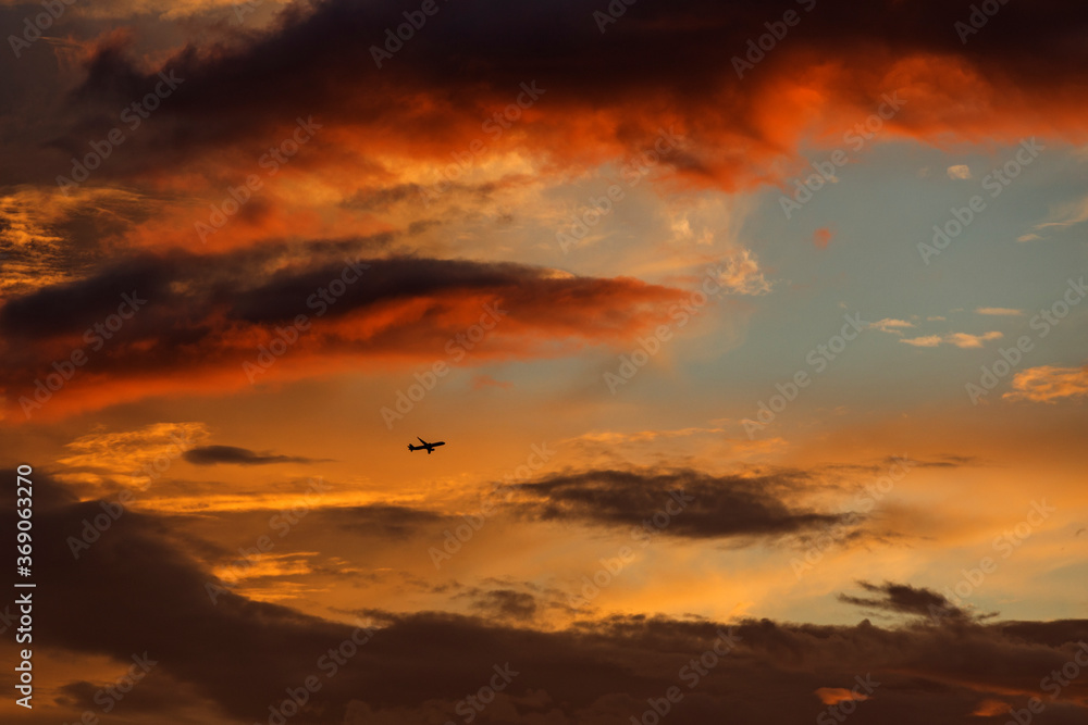 Obraz premium Plane on red sky in sunset