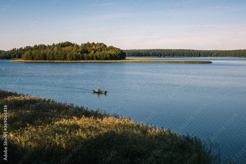 Angler in a boat on the Wigry lake near Wigierski National Park, Podlaskie, Poland