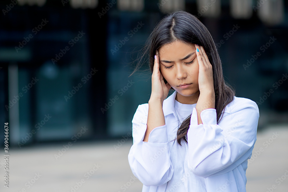 Serious asian ethnic female student suffering from headache. young dissapointed girl in white clothes, shirt. Bad news, frustrated negative emotion. Problems with health, head Serious asian ethnic female student suffering from headache. young dissapointed girl in white clothes, shirt. Bad news, frustrated negative emotion. Problems with health, head