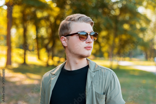 Portrait of handsome young stylish man with sunglasses standiing outdoor.