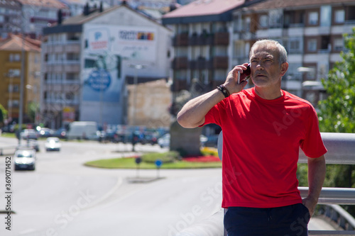 mature man doing sports and using mobile phone in the city © tetxu