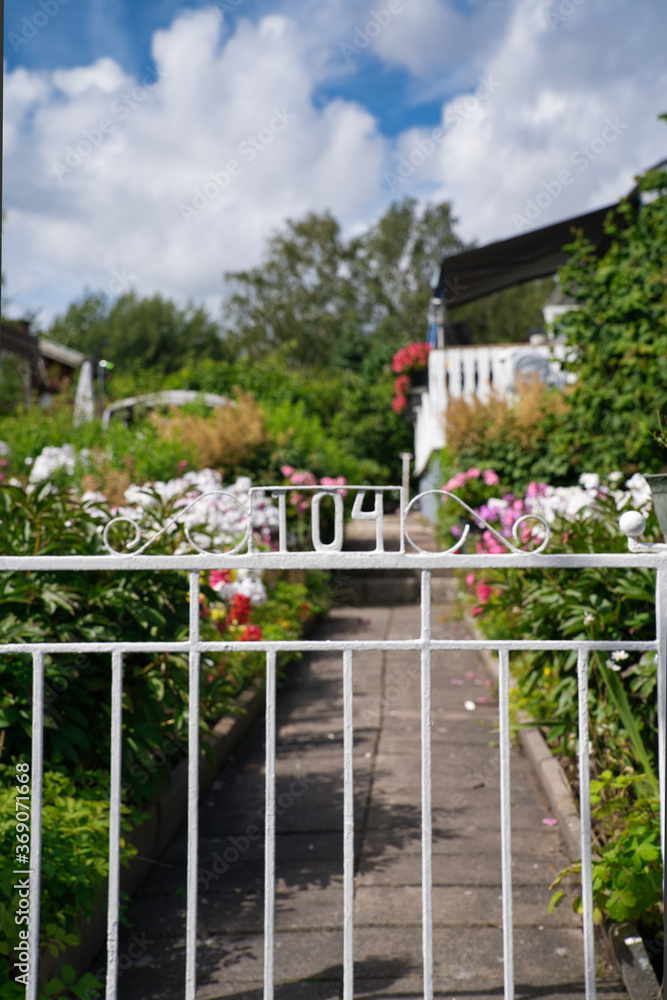White fence, garden with flowers in the background