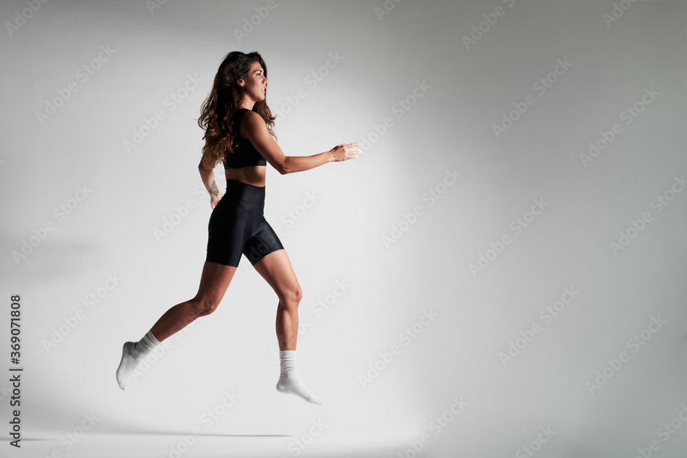 fitness girl dressed in black , doing a jump fitness girl dressed in black , doing a jump