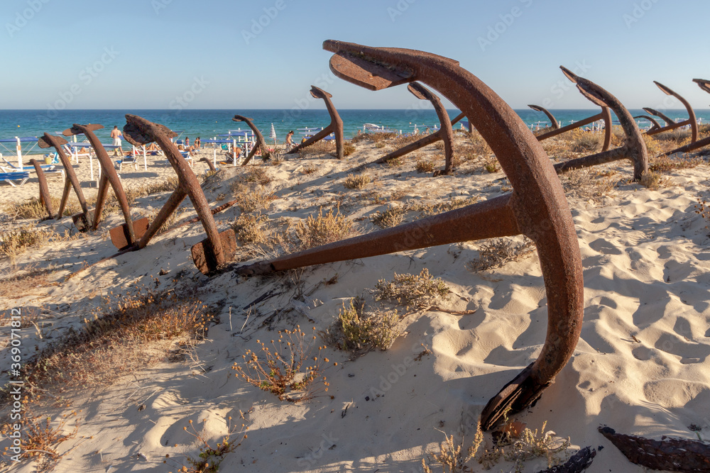 Fototapeta premium A view of the unique beach Praia do Barril in Portugal, where hundreds of rusty anchors rest in what is called the Cemitery of Anchors.