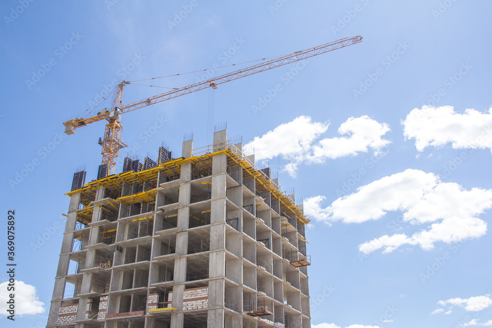Construction at the background of blue sky. Rresidential building. Reinforced concrete frame of the building. Construction at the background of blue sky. Rresidential building. Reinforced concrete frame of the building.