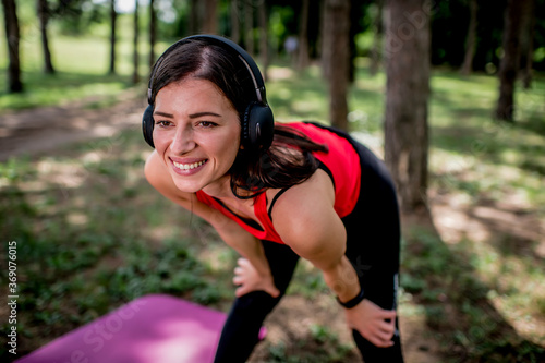 Portrait of sporty young woman listening to music outdoors
