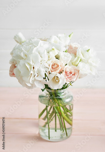 Bouquet of roses, eustomas and hydrangeas on table. Cup of tea and photo frame. Greeting card for mothers day. Cozy good morning. Happy Birthday. Wedding invitation. Flowers composition for Valentine