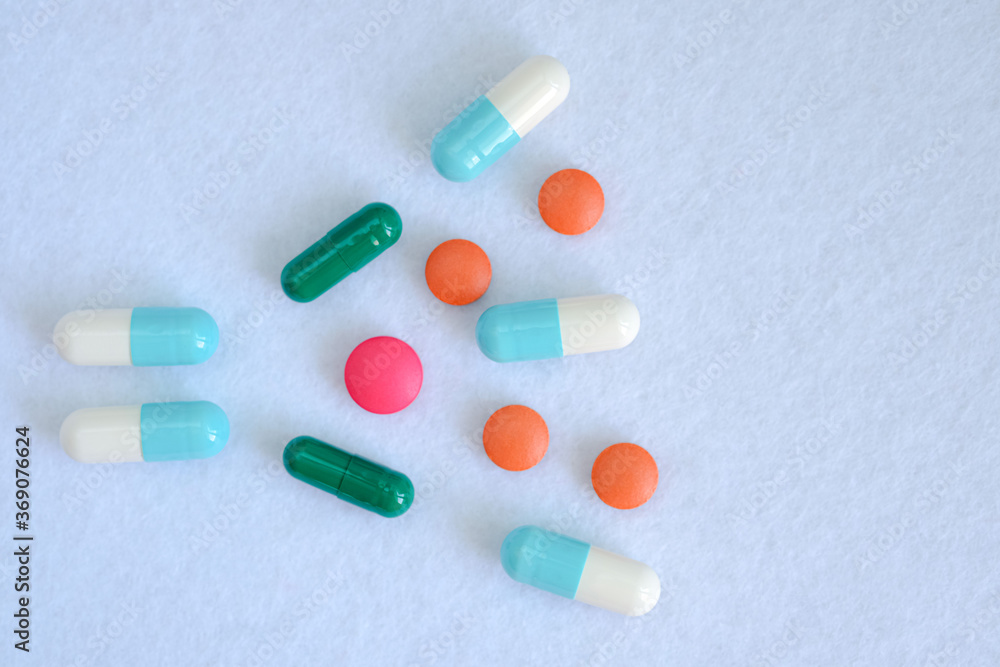 Pills tablets and capsules are scattered over a white background. Pills tablets and capsules are scattered over a white background.